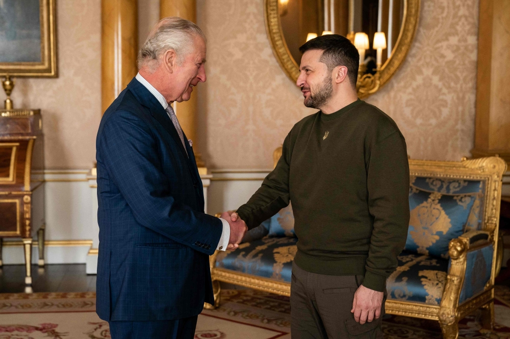 King Charles III shakes hands with Ukraine's President Volodymyr Zelensky at Buckingham Palace, in London, during his first visit to the UK since the Russian invasion of Ukraine. (Photo by Aaron Chown / POOL / AFP)