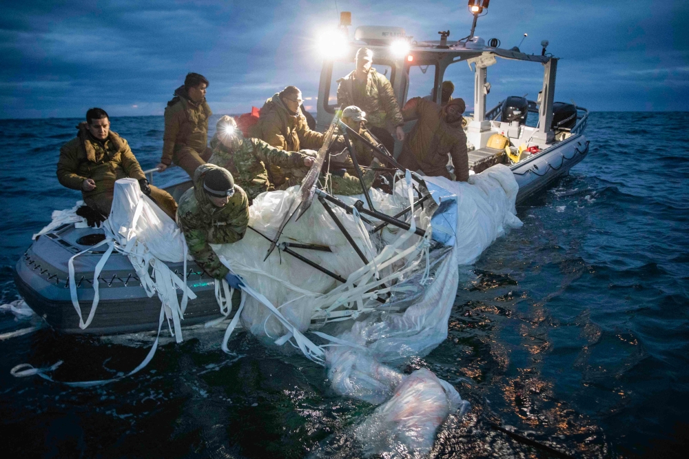 This picture provided by the US Navy shows sailors assigned to Explosive Ordnance Disposal Group 2 recover a high-altitude surveillance balloon off the coast of Myrtle Beach, South Carolina, in the Atlantic ocean on February 5, 2023.  (Photo by Petty Officer 1st Class Tyler Thompson / US NAVY / AFP)