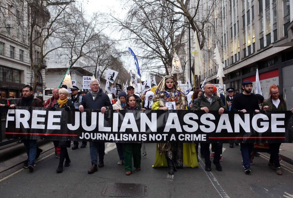Supporters of WikiLeaks founder Julian Assange take part in a 'Night Carnival for Assange' march in London on February 11, 2023. (Photo by Susannah Ireland / AFP)