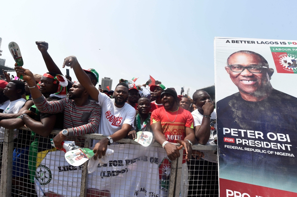 Supporters chant party slogans next to a banner of the candidate of the Labour Party Peter Obi during a campaign rally of the party in Lagos, on February 11, 2023. (Photo by PIUS UTOMI EKPEI / AFP)