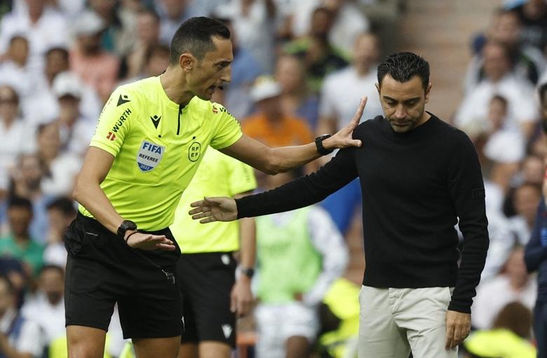 Real Madrid v FC Barcelona - Santiago Bernabeu, Madrid, Spain - October 16, 2022 Referee Jose Maria Sanchez Martinez talks to FC Barcelona coach Xavi REUTERS/Susana Vera