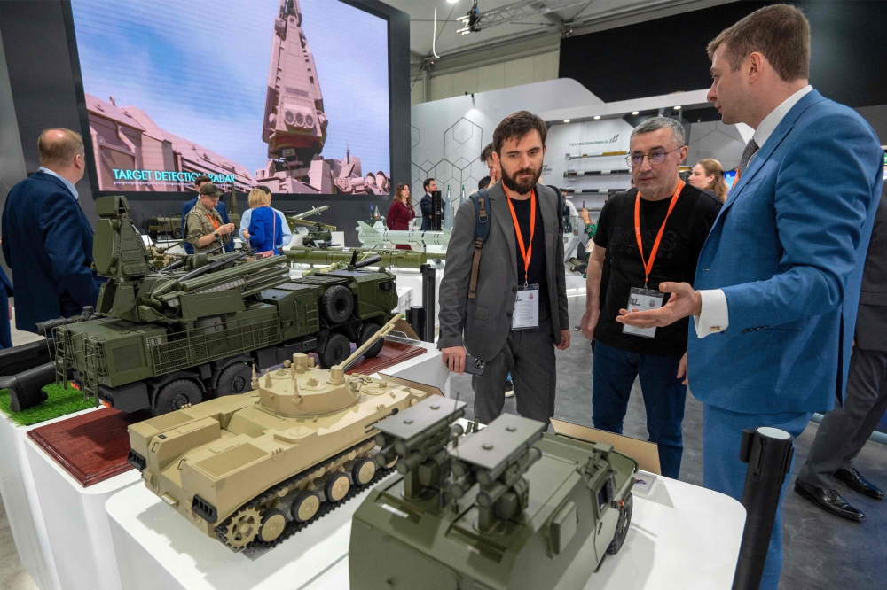 Visitors view mockups of ground vehicles as they tour the Russian pavilion during the International Defence Exhibtion (IDEX) at the Abu Dhabi International Exhibition Centre on February 20, 2023. (Photo by Ryan Lim / AFP)