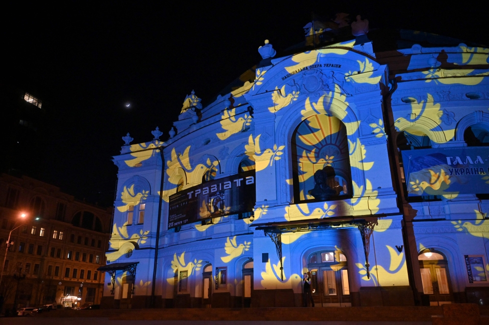 A light installation by Swiss artist Gerry Hofstetter is projected on the main Post Office building in Kyiv on February 23, 2023, on the eve of first anniversary of the Russian invasion to Ukraine. (Photo by Sergei Supinsky / AFP) 