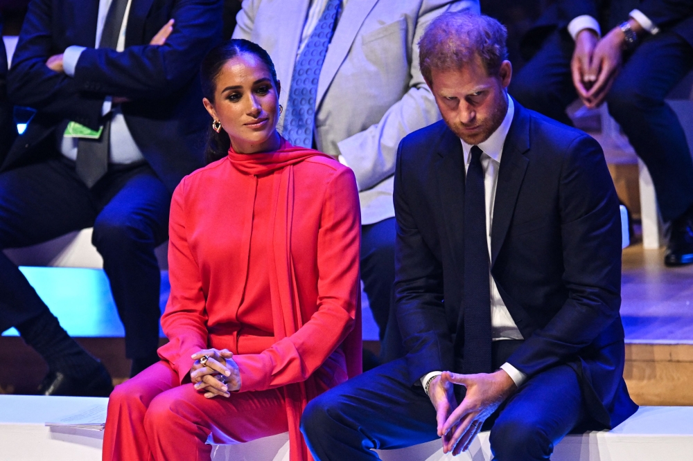 In this file photo taken on September 5, 2022 Britain's Meghan, Duchess of Sussex and Britain's Prince Harry, Duke of Sussex, react as they attend the annual One Young World Summit at Bridgewater Hall in Manchester, northwest England. (Photo by Oli SCARFF / AFP)