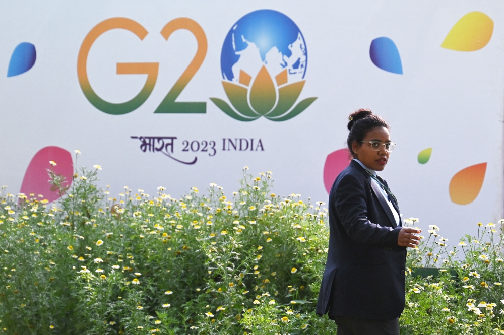 A security personnel gestures beside a hoarding during the G20 Foreign Minister meeting in New Delhi on March 2, 2023. (Photo by Arun SANKAR / AFP)
