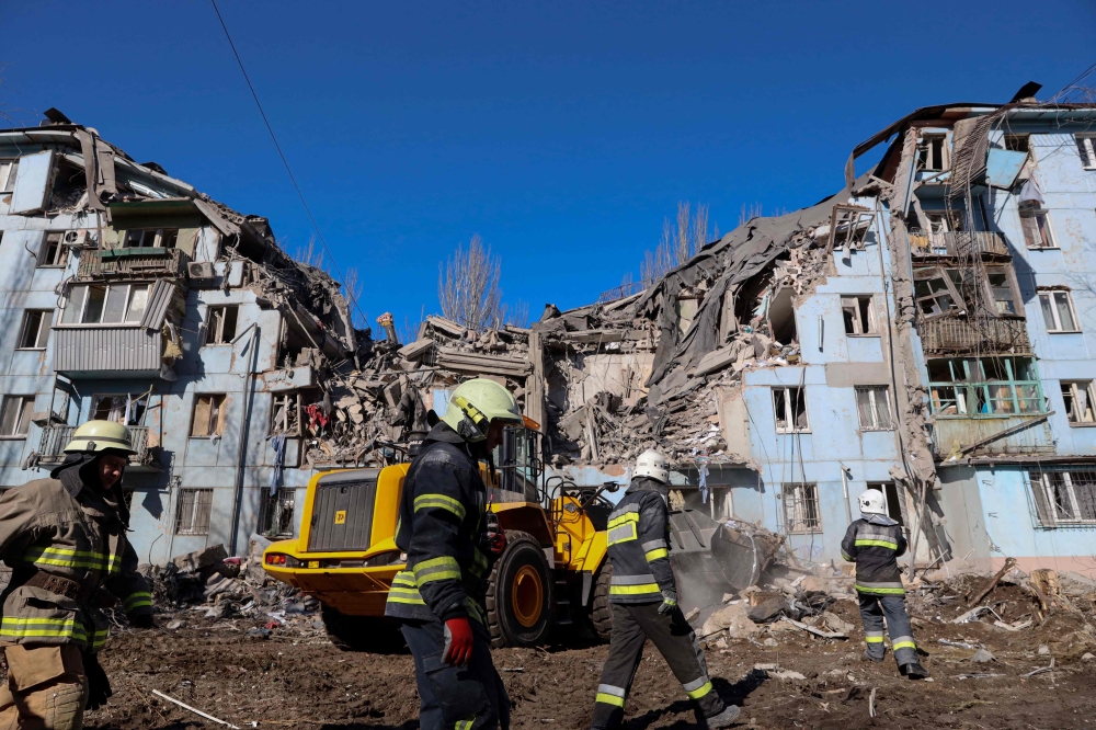 Ukrainian rescuers work on the five-storey residential building destroyed after a missile strike in Zaporizhzhia on March 2, 2023, amid the Russian invasion of Ukraine. (Photo by Katerina Klochko / AFP)