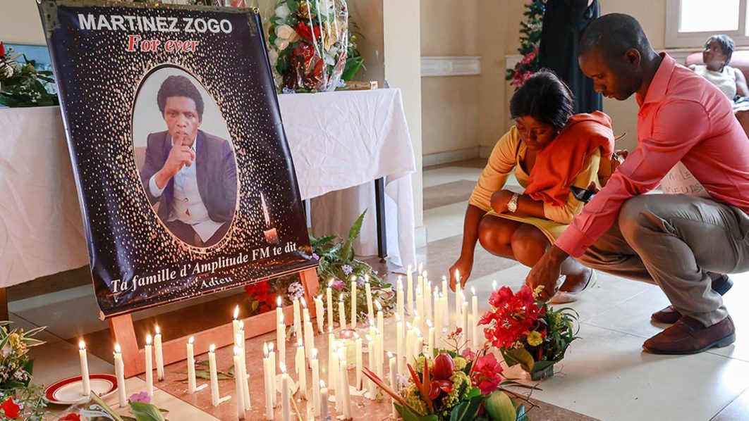 Mourners place candles in a room of Radio Amplitude FM where a portrait of journalist Martinez Zogo has been placed to pay tribute to him, in the Elig Essono district in Yaounde on January 23, 2023. File photo / AFP