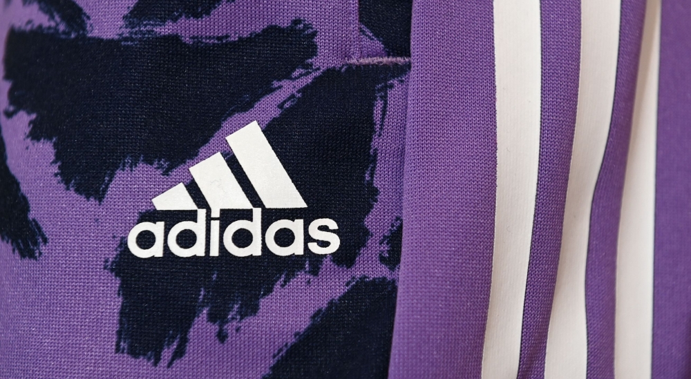 The logo of the German sports equipment maker Adidas is pictured prior to the company's annual press conference in Herzogenaurach, southern Germany on March 8, 2023. (Photo by Christof STACHE / AFP)