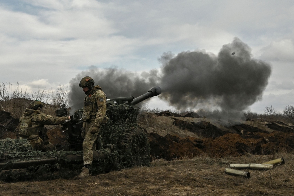 Ukrainian servicemen fire with a 105mm howitzer towards Russian positions near the city of Bakhmut, on March 8, 2023, amid the Russian invasion of Ukraine. (Photo by Aris Messinis / AFP)