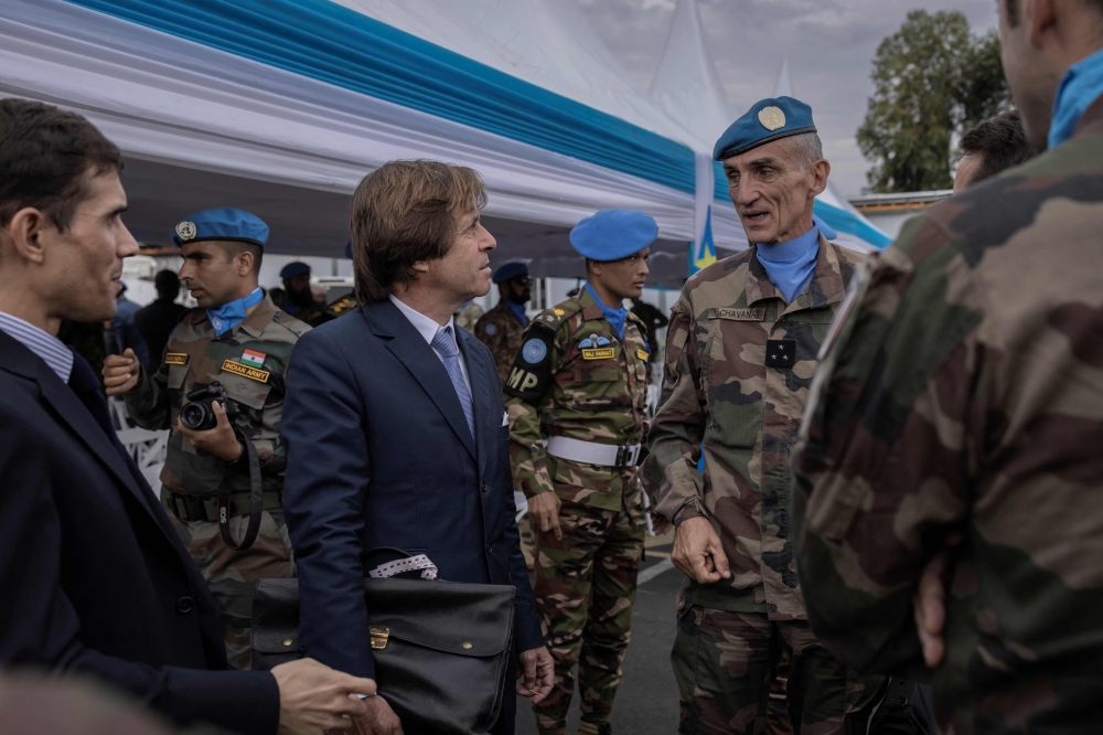 Nicolas de Rivière (third left), Permanent Representative of France to the United Nations, United Nations Organization Stabilization Mission in the Democratic Republic of the Congo (MONUSCO), speaks with peacekeepers during a ceremony in honour of peacekeepers killed in the line of duty since the mission began, in Goma on March 11, 2023. (Photo by Guerchom Ndebo / AFP)