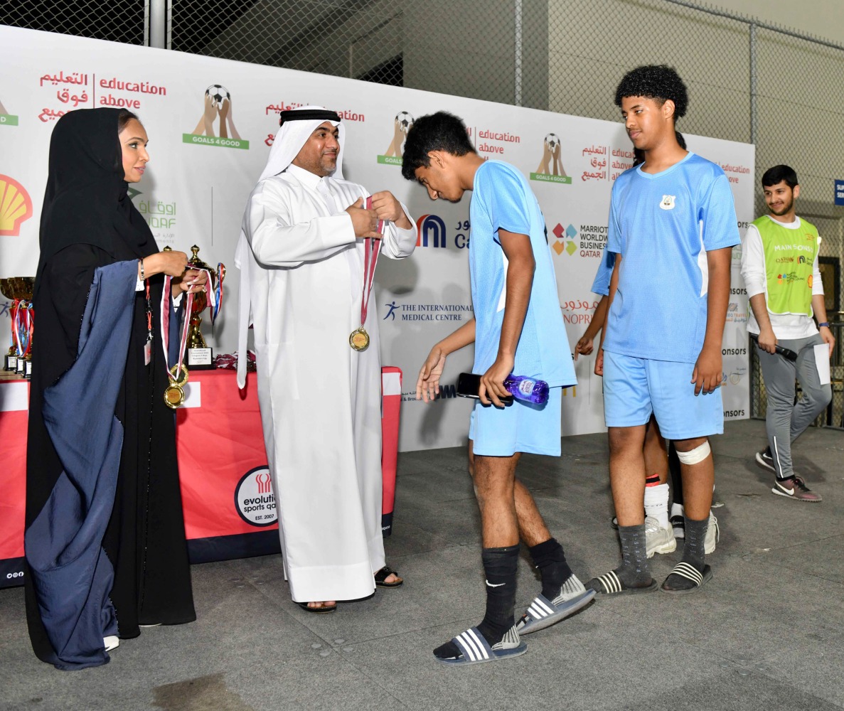 Chief Administrative Officer of QIC Group Rashid Al Buainain presents the medal to a student.
