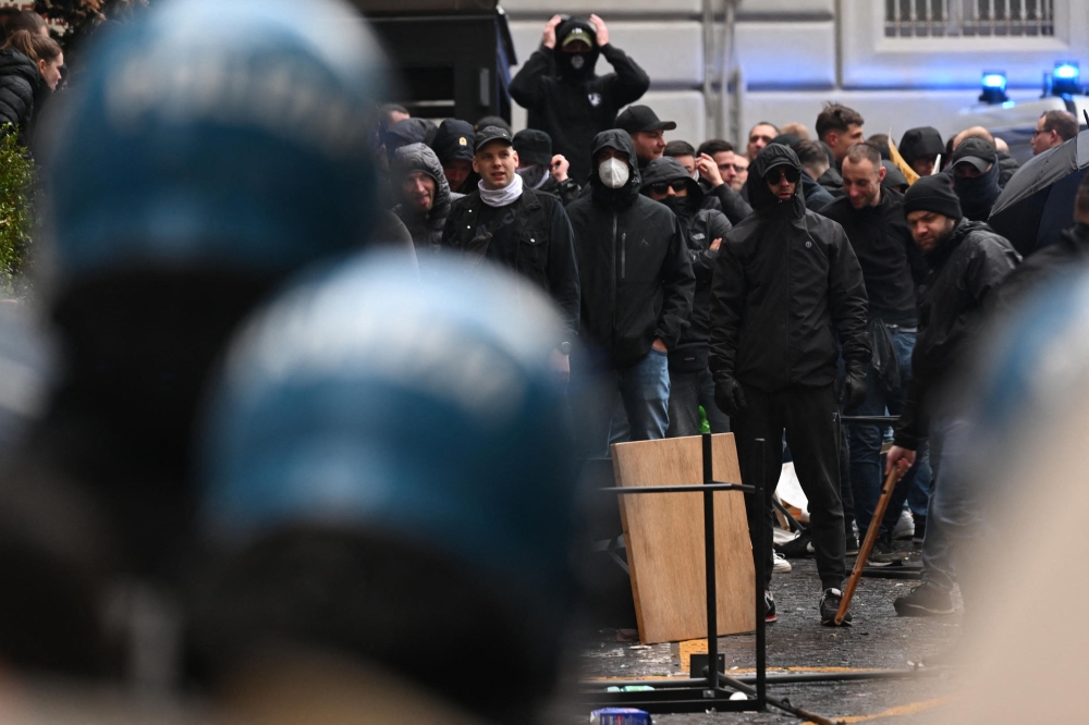 This photo obtained from Italian news agency Ansa shows Eintracht Frankfurt fans (Rear) facing anti-riot police (Front) within clashes on March 15, 2023 in downtown Naples prior to the UEFA Champions League round of 16, second leg football match between SSC Napoli and Eintracht Frankfurt to be played at the Diego-Maradona stadium in Naples. Photo by Ciro FUSCO / ANSA / AFP