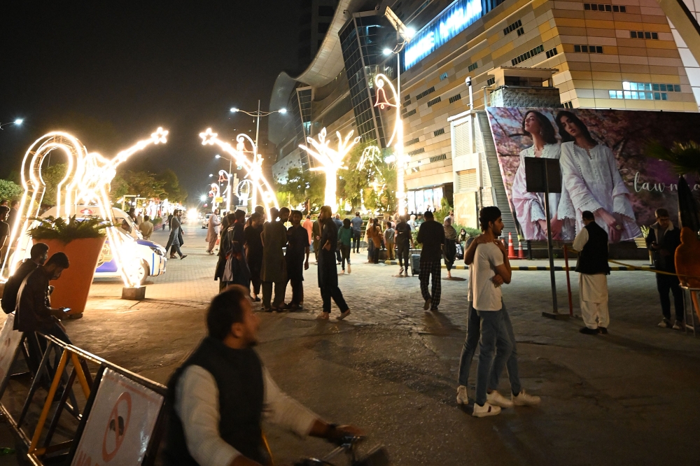People gather outside a mall following an earthquake in Islamabad, Pakistan, on March 21, 2023. - A strong earthquake lasting for at least 30 seconds was felt across much of Afghanistan, Pakistan and parts of India, with the United States Geological Survey putting the magnitude at 6.5. (Photo by Aamir QURESHI / AFP)