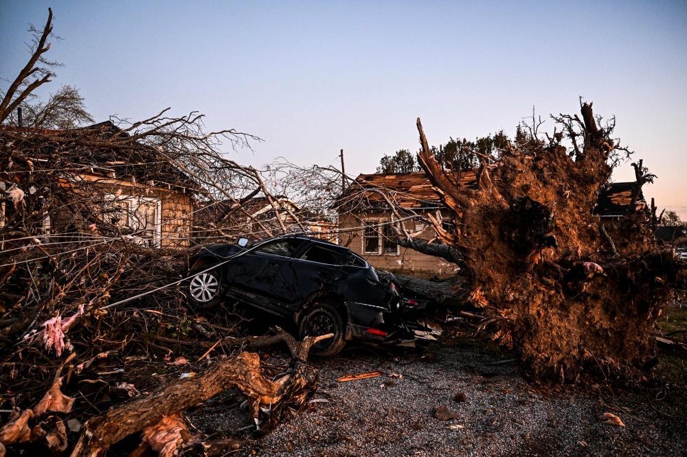 The remains of a house and cars are entangled in tree limbs in Rolling Fork, Mississippi, on March 25, 2023, after a tornado touched down in the area. (Photo by Chandan Khanna / AFP)