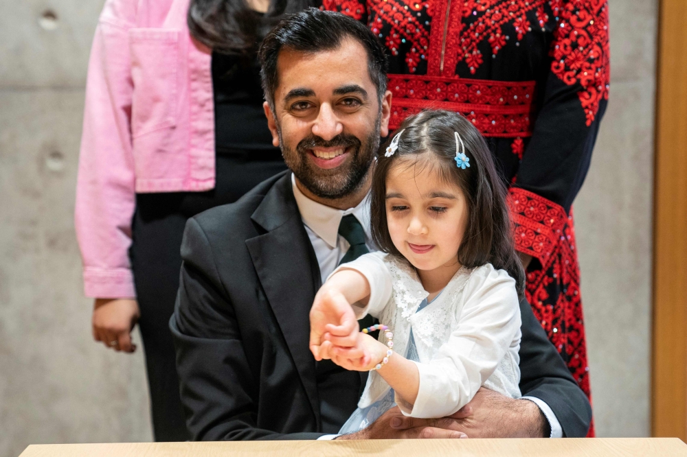 Newly elected leader of the Scottish National Party, Humza Yousaf poses with his daughter Amal after signing the nomination form to become First Minister for Scotland, at the Scottish Parliament in Edinburgh, on March 28, 2023 ahead of the MP's vote concerning his nomination to be Scotland's sixth First Minister. (Photo by Jane Barlow / POOL / AFP)