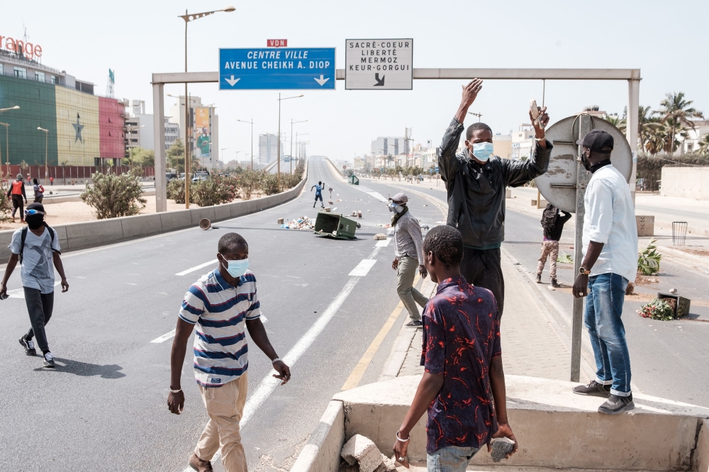 Protesters gather at a road block on a highway in Dakar on March 30, 2023. - Senegal, a rare island of stability in the troubled West African region, is seeing another tense week with the resumption of the libel trial against Ousmane Sonko on Thursday. Sonko and his supporters accuse the government of using the justice system to prevent him from running in next year's presidential election. (Photo by GUY PETERSON / AFP)