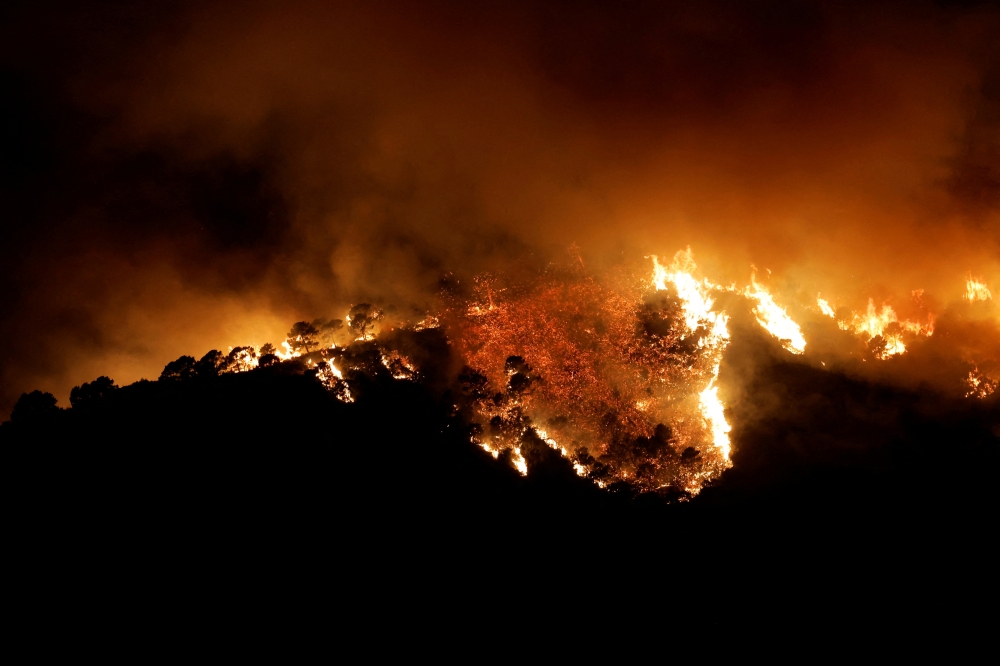 File Photo: A forest fire is seen in Benahavis, Spain, June 8, 2022. (REUTERS/Jon Nazca)