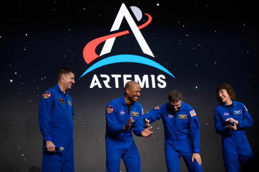 (L-R) Astronauts Jeremy Hansen, Victor Glover, Reid Wiseman and Christina Hammock Koch celebrate after being selected for the Artemis II mission who will venture around the Moon during a news conference held by NASA and CSA at Ellington airport in Houston, Texas, on April 3, 2023. (Photo by Mark Felix / AFP)