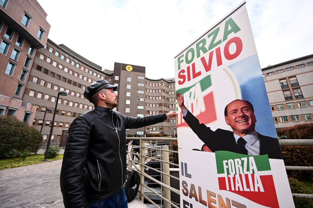 A man sets up a banner reading 