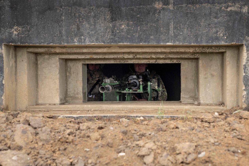 A member of Ukraine's National Guard stands guard in a bunker at a Ukrainian National Guard position near Odesa, on April 10, 2023 amid the Russian invasion of Ukraine. (Photo by Bo Amstrup / Ritzau Scanpix / AFP)