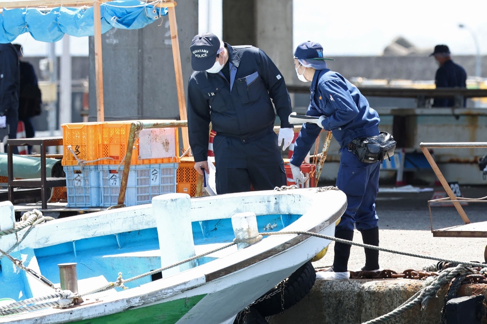 Police officers investigate Saikazaki port, where Japan's Prime Minister Fumio Kishida was evacuated unharmed from the scene of an apparent 
