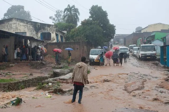 File photo: Residents walk in a street following heavy rains after cyclone Freddy made landfall in Mozambique and Malawi killing over 100 people.(Photo by Amos Gumulira / AFP)