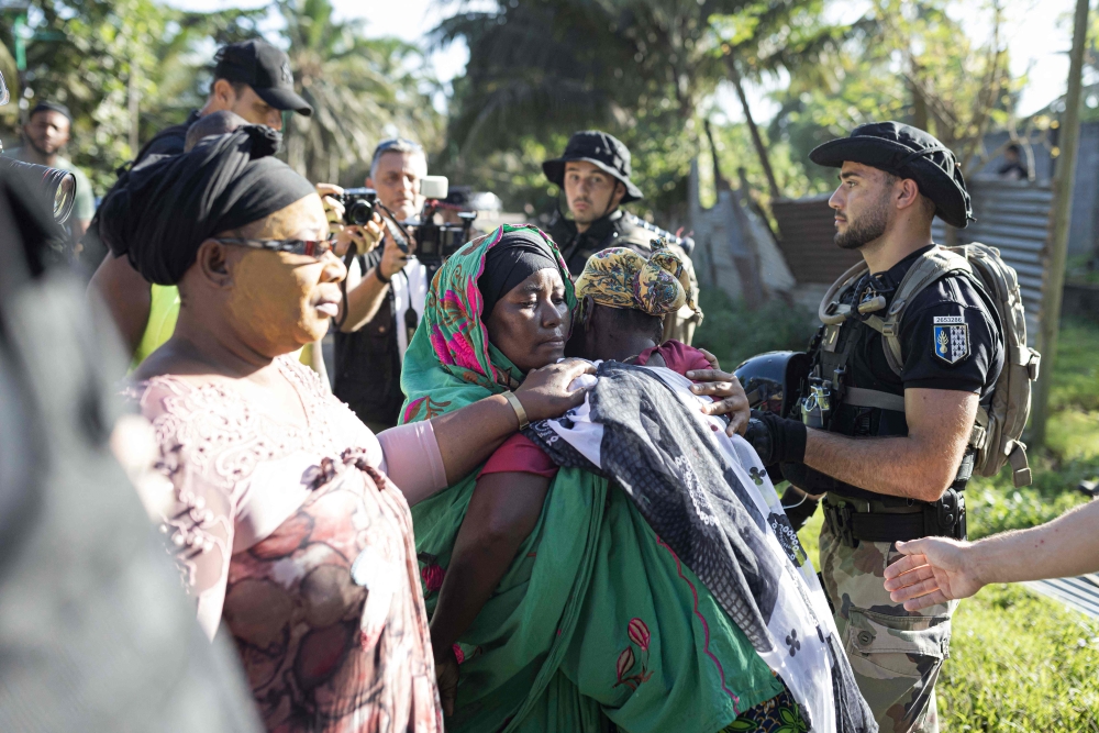 People react during the demolition of an informal settlement in Langoni, Mamoudzou, on the island of Mayotte on April 27, 2023. (Photo by Patrick Meinhardt / AFP)