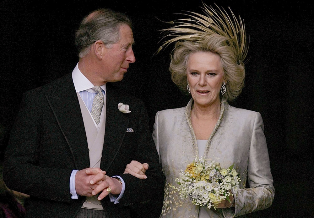 In this file photo taken on April 9, 2005 Britain's Prince Charles and his bride Camilla, Duchess of Cornwall leave St. George's Chapel in Windsor. (Photo by Alastair Grant / POOL / AFP)