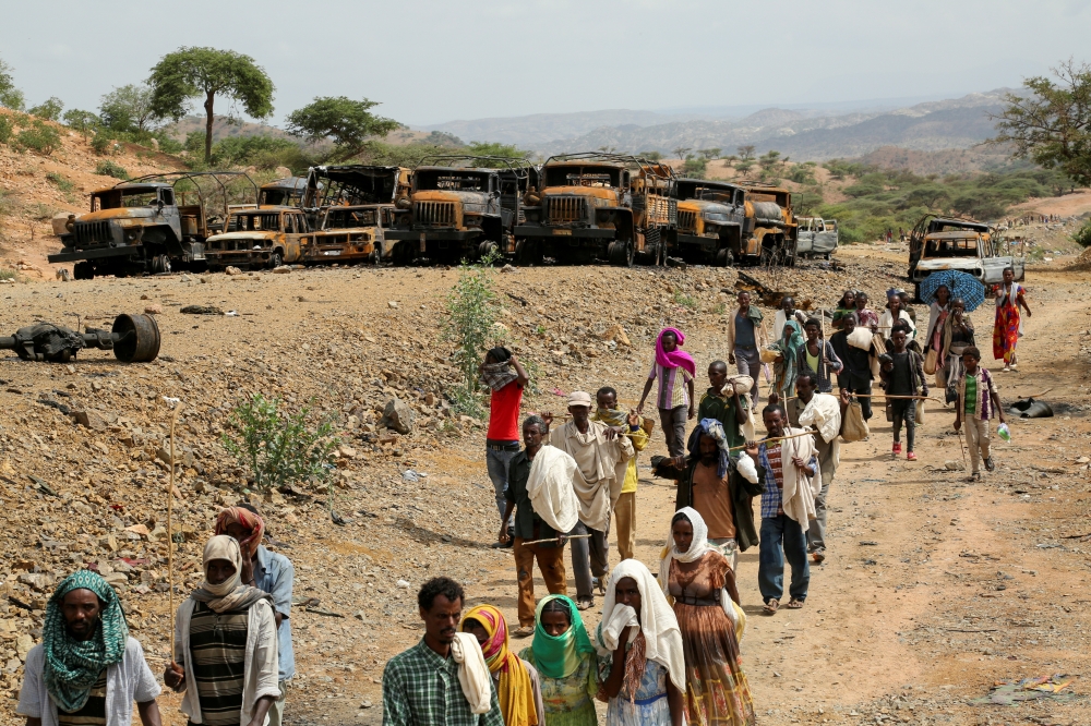 File Photo: Villagers return from a market to Yechila town in south central Tigray walking past scores of burned vehicles, in Tigray, Ethiopia, July 10, 2021. (REUTERS)