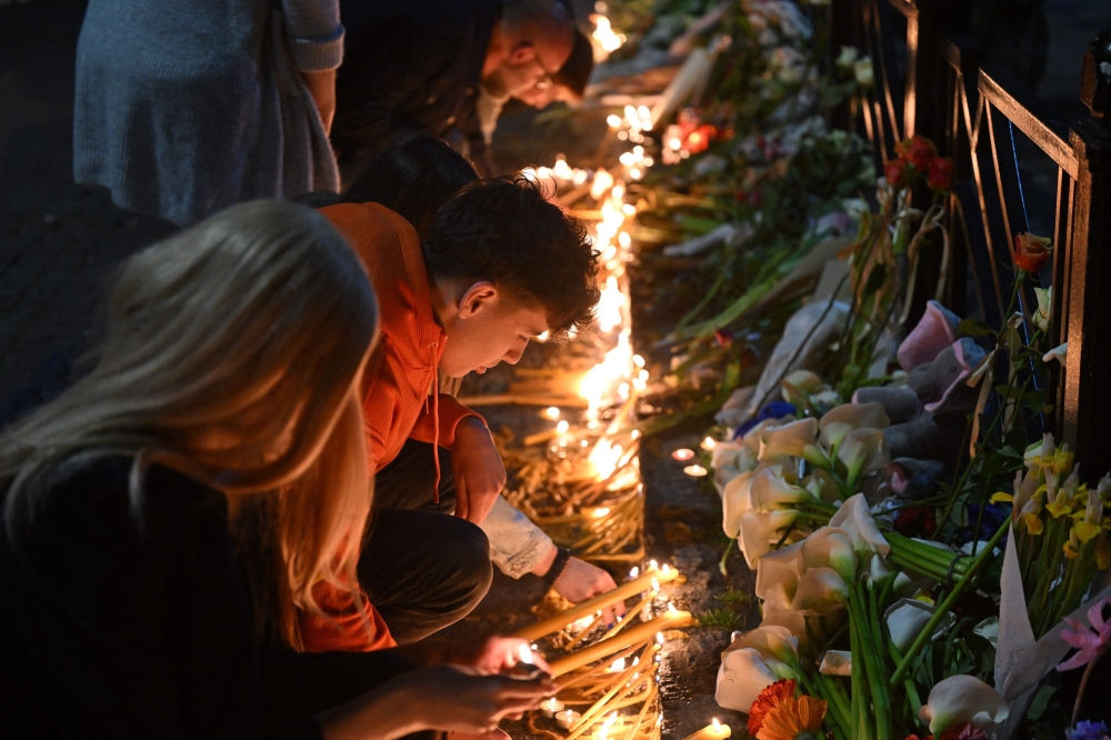People light candles at a makeshift memorial for the victims following a shooting at a school in the Serbian capital Belgrade on May 3, 2023. Photo by ANDREJ ISAKOVIC / AFP