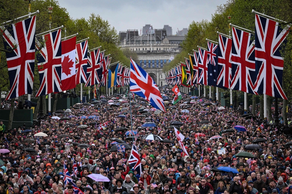 Well-wishers gather on The Mall to celebrate Britain's King Charles III and Britain's Queen Camilla, in central London, on May 6, 2023 following of their coronations. Photo by Marco BERTORELLO / AFP