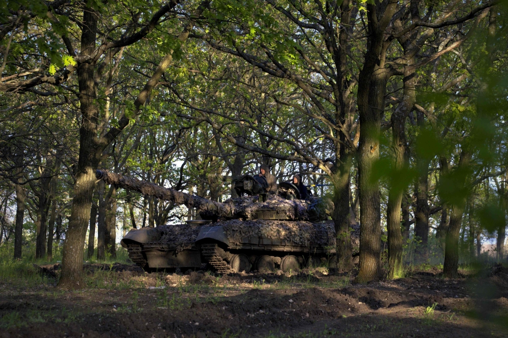 Ukrainian servicemen of the Adam tactical group ride a T-64 tank from a front line near the town of Bakhmut, Donetsk region, on May 7, 2023, amid the Russian invasion of Ukraine. (Photo by Sergey Shestak / AFP)