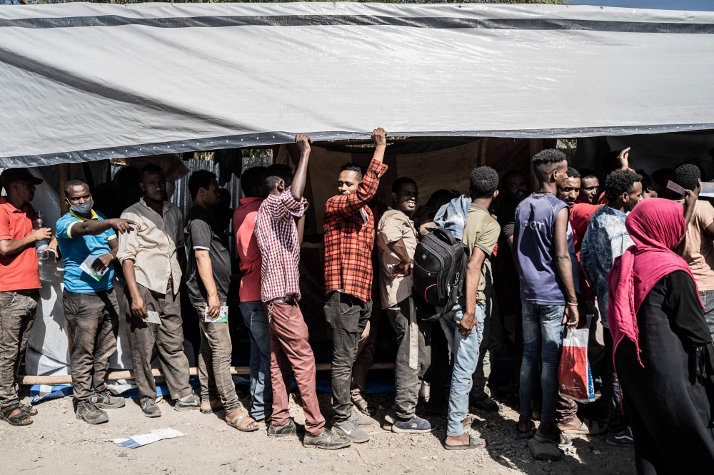 Refugees who crossed from Sudan to Ethiopia wait in line to register at IOM (International organization for Migration) in Metema, on May 4, 2023. (Photo by Amanuel Sileshi / AFP)