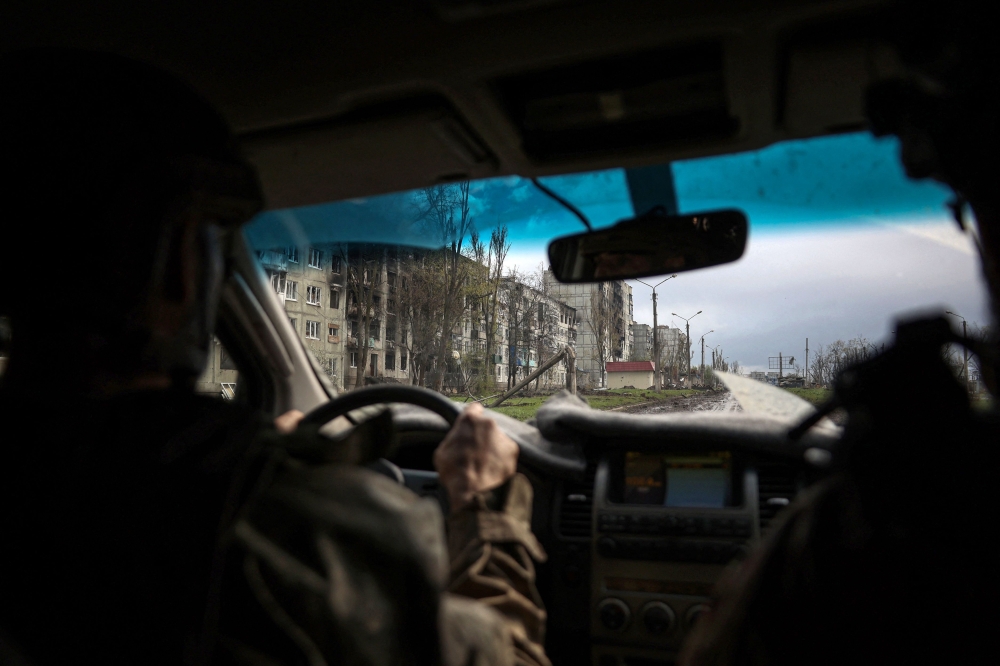 Ukrainian serviceman drives a car down a street near residential buildings damaged by shelling in the frontline city of Bakhmut, Donetsk region, on April 23, 2023, amid the Russian invasion of Ukraine.   (Photo by Anatolii Stepanov / AFP)