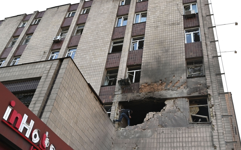 A local resident examines a partially destroyed residential building after a massive Russian drones strike mainly targetting the Ukrainian capital, in Kyiv, on May 28, 2023. (Photo by Sergei Supinsky / AFP)