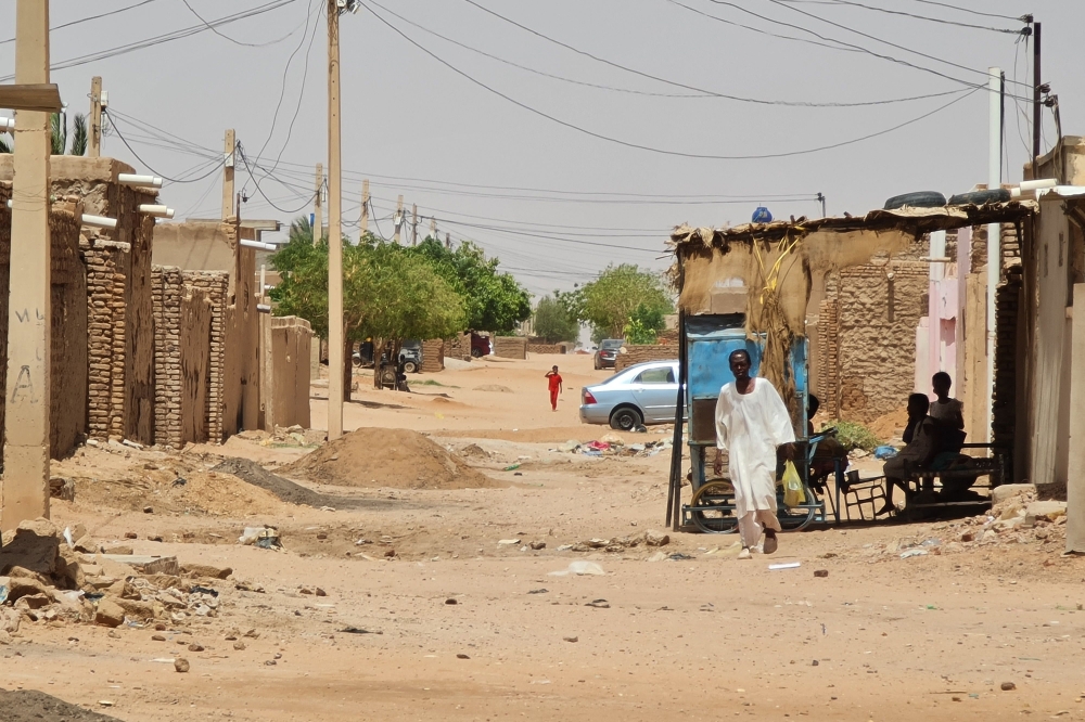 A man walks in a street in Khartoum on June 19, 2023. (Photo by AFP)