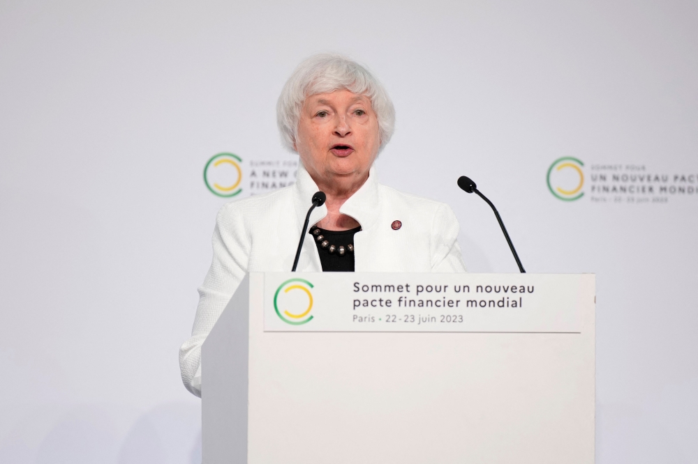 US Treasury Secretary Janet Yellen (C) speaks next to French President Emmanuel Macron (L) and World Bank President Ajay Banga (R) during the closing session of the New Global Financial Pact Summit, in Paris on June 23, 2023. (Photo by Lewis Joly / POOL / AFP)