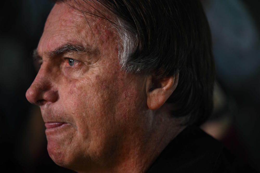 Former Brazilian President Jair Bolsonaro gestures as he speaks to members of the media upon arrival at the Santos Dumont Airport in Rio de Janeiro, Brazil, on June 29, 2023. (Photo by MAURO PIMENTEL / AFP)
