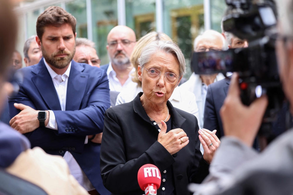 :French Prime Minister Elisabeth Borne addresses journalists in front of the Mayor of L'Hay-les-Roses, Vincent Jeanbrun (L), after rioters rammed a vehicle into his house overnight, in L'Hay-les-Roses, south of Paris on July 2, 2023. (Photo by CHARLY TRIBALLEAU / POOL / AFP)
