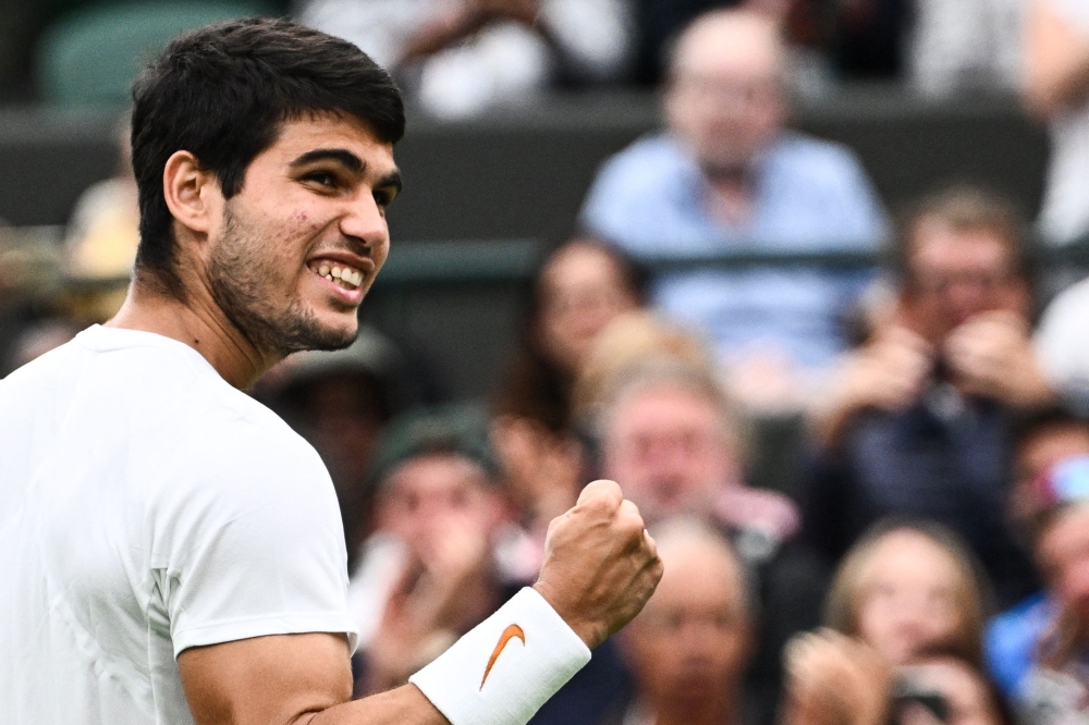 Spain's Carlos Alcaraz celebrates winning against France's Jeremy Chardy during their men's singles tennis match on the second day of the 2023 Wimbledon Championships at The All England Tennis Club in Wimbledon, southwest London, on July 4, 2023. (Photo by SEBASTIEN BOZON / AFP)