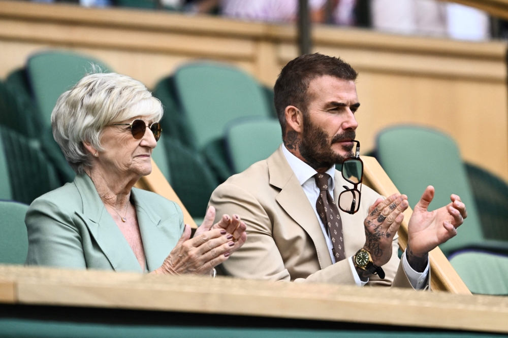 Former British football player David Beckham and his mother Sandra Beckham applaud as they sit in the royal box in Center Court during the women's singles tennis match between Russia's Daria Kasatkina and Britain's Jodie Burrage on the third day of the 2023 Wimbledon Championships at The All England Tennis Club in Wimbledon, southwest London, on July 5, 2023. (Photo by SEBASTIEN BOZON / AFP)
