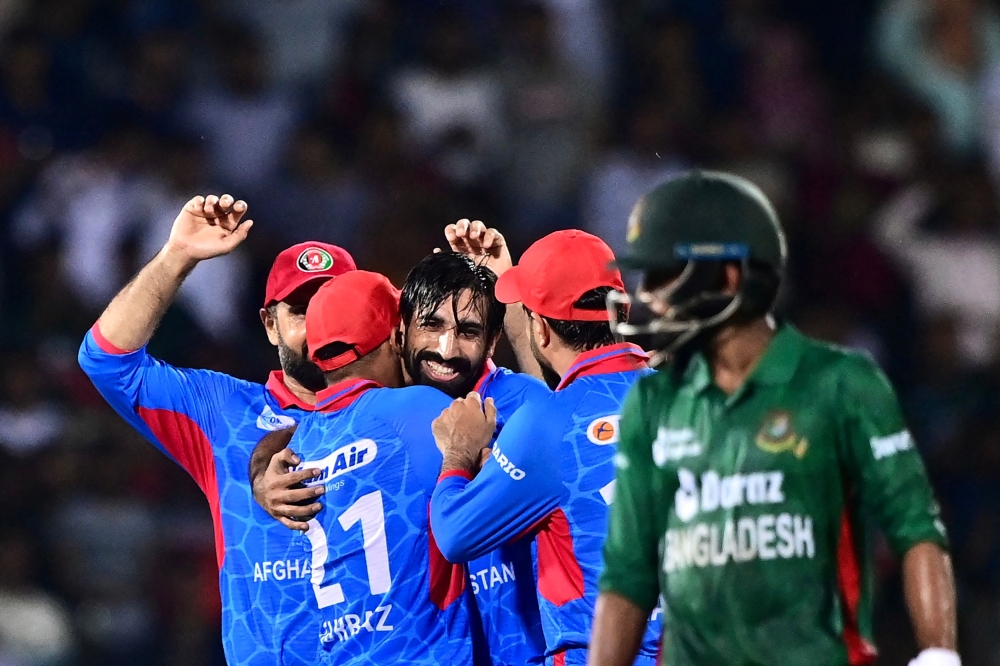 Afghanistan's Karim Janat (C) celebrates with teammates after taking a hat-trick during the first Twenty20 international cricket match between Bangladesh and Afghanistan at the Sylhet International Cricket Stadium in Sylhet on July 14, 2023. (Photo by Munir uz ZAMAN / AFP)