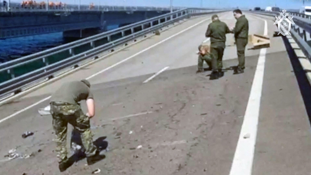 This video grab taken and released on July 17, 2023 by the Russian Investigative Commitee shows committee investigators working on the Kerch bridge -- linking Crimea to Russia -- which was heavily damaged following an attack. (Photo by Russian Investigative Commitee / AFP) 