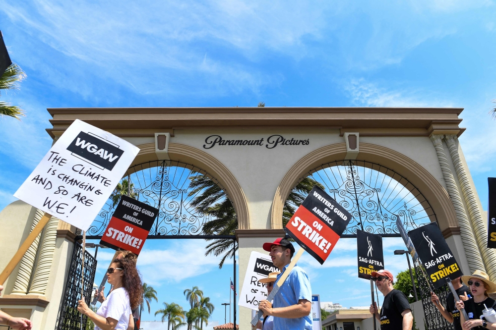 Members of the Writers Guild of America and the Screen Actors Guild walk a picket line outside of Paramount Pictures, in Los Angeles, California, on July 21, 2023. (Photo by VALERIE MACON / AFP)