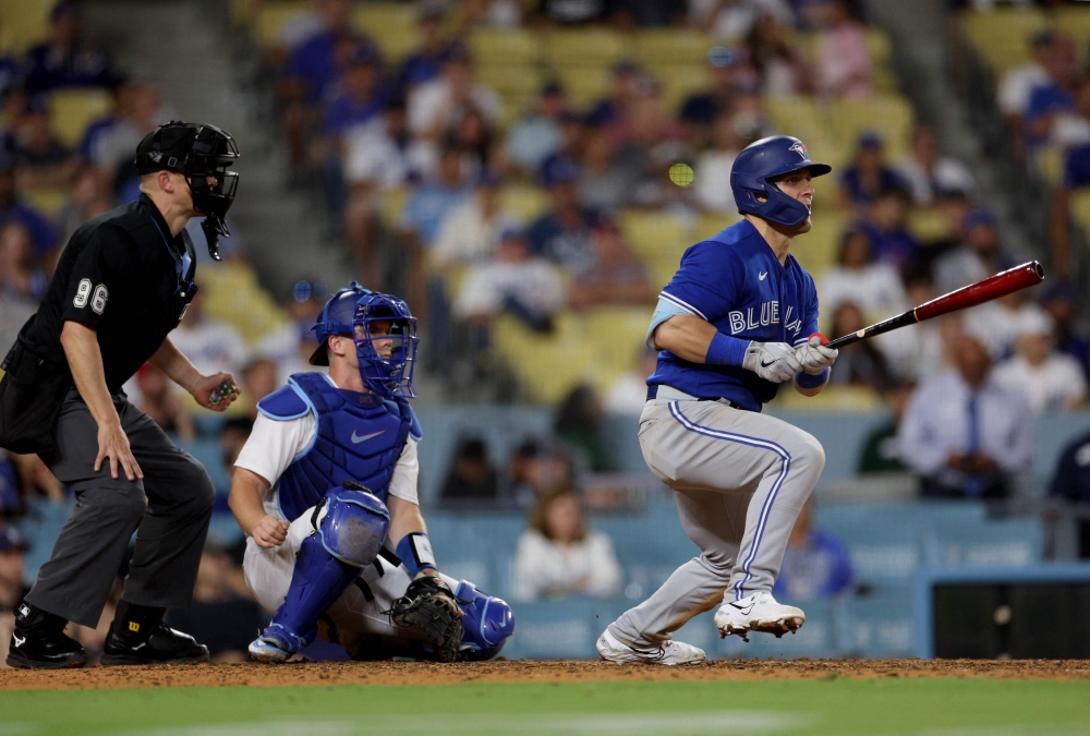 Daulton Varsho #25 of the Toronto Blue Jays watches his two run double with Will Smith #16 of the Los Angeles Dodgers and umpire Chris Segal, to take a 5-3 lead, during the 11th inning at Dodger Stadium on July 24, 2023 in Los Angeles, California. (Photo by Harry How / GETTY IMAGES NORTH AMERICA / Getty Images via AFP)
