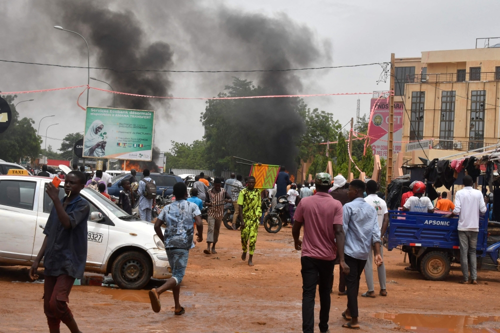 A general view of billowing smoke as supporters of the Nigerien defence and security forces attack the headquarters of the Nigerien Party for Democracy and Socialism (PNDS), the party of overthrown President Mohamed Bazoum, in Niamey on July 27, 2023. (Photo by AFP)
