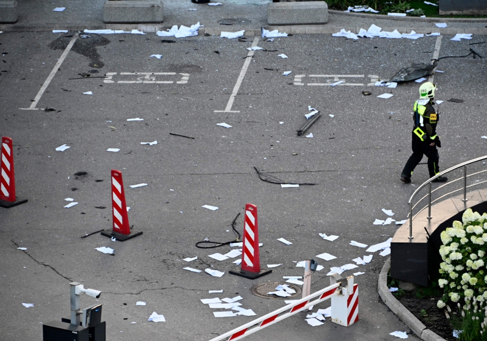A firefighter walks among papers and broken glass outside a damaged office block of the Moscow International Business Center (Moskva City) following a reported drone attack in Moscow on July 30, 2023. (Photo by Alexander Nemenov / AFP)