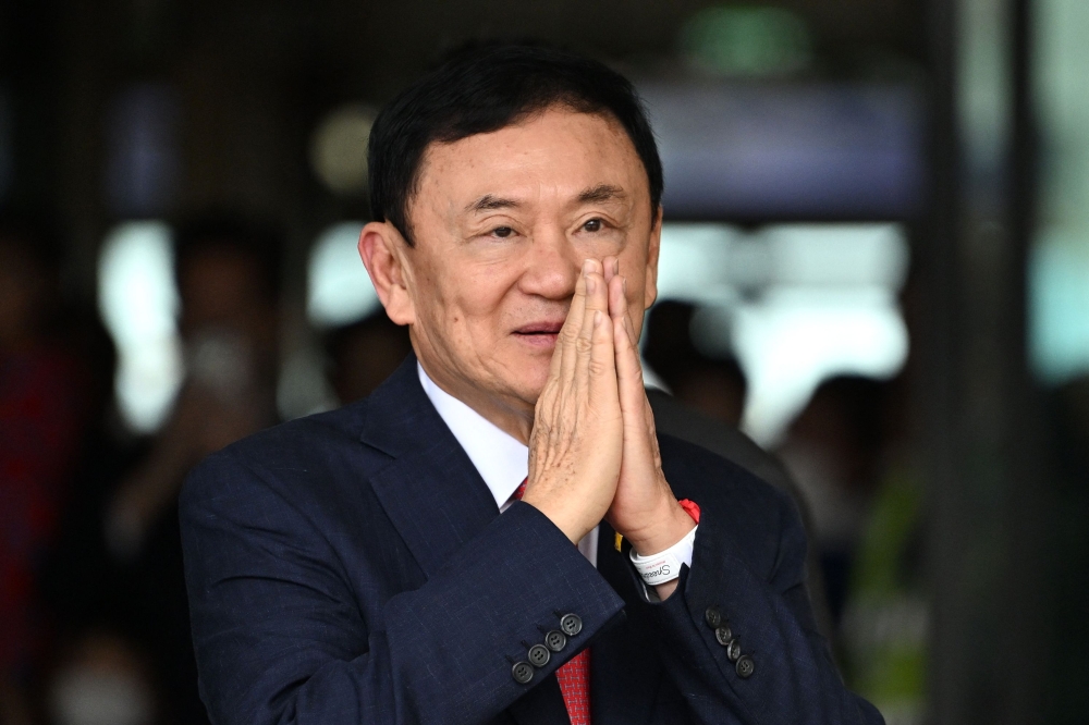 Former Thai Prime Minister Thaksin Shinawatra greets his supporters after landing at Bangkok's Don Mueang airport on August 22, 2023. (Photo by Manan Vatsyayana / AFP)