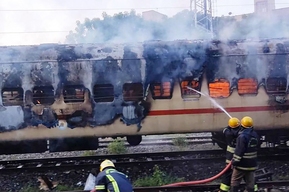 Firefighters try to extinguish a fire which broke out in a train coach parked at the Madurai railway yard, in Madurai on August 26, 2023. (Photo by AFP)