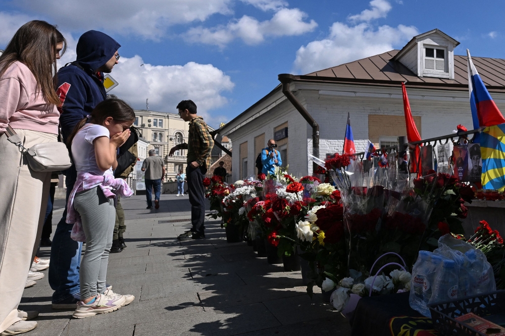 People pay tribute to late head of Wagner paramilitary group, Yevgeny Prigozhin at a makeshift memorial in Moscow, on August 27, 2023. (Photo by Natalia Kilesnikova / AFP)
